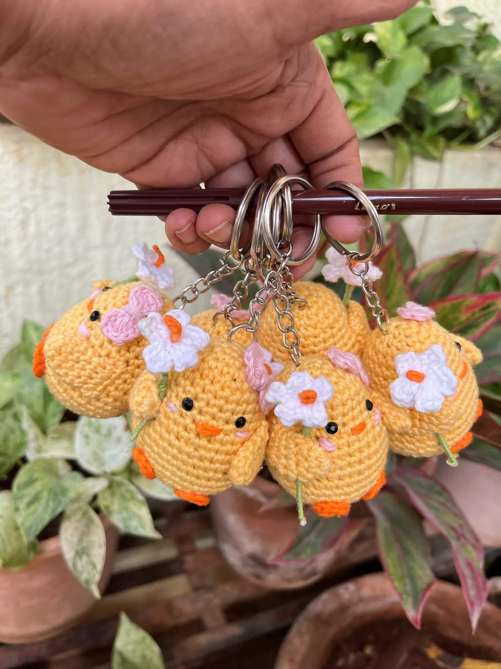 Cluster of yellow crochet chick keychains with flower details